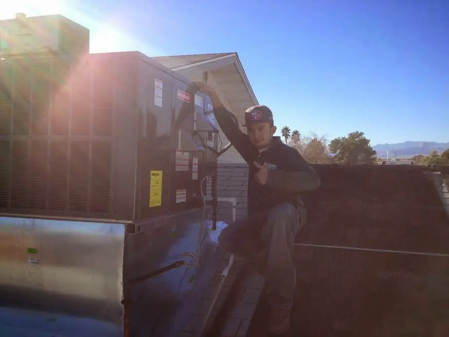 HVAC technician performing AC Tune-Up on a rooftop unit in Hoffman Estates